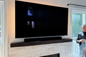 Technician mounting a flat screen TV on a living room wall